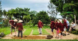 Die Touristen beteiligen an Gartenarbeit im Gemüsedorf Tra Que