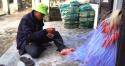 Ein lokaler Fischer knüpft selber sein Fischnetz