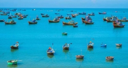 Bunte Fischboote auf dem türkisblauen Wasser von Mui Ne