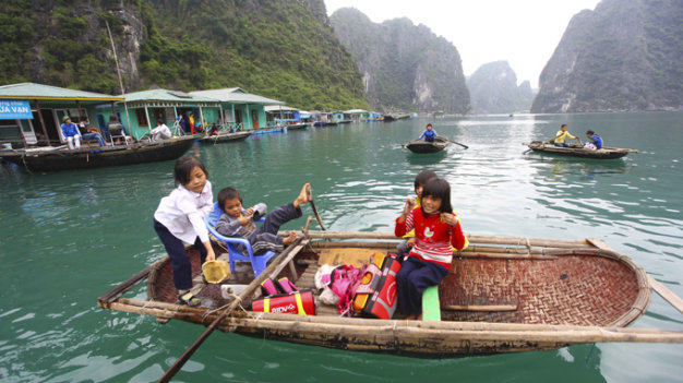 Kinder auf einem Boot im Dorf Cua Van, Halong-Bucht
